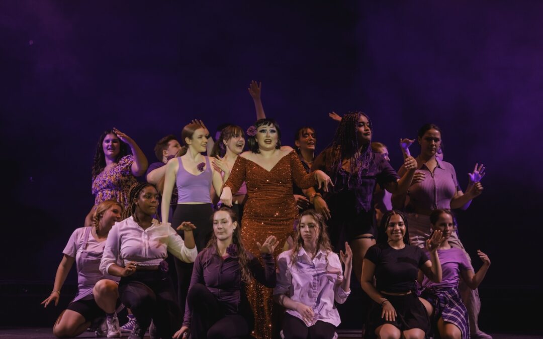 Westinghouse Arts Academy charter public high school students on stage in a spotlight with a purple backdrop