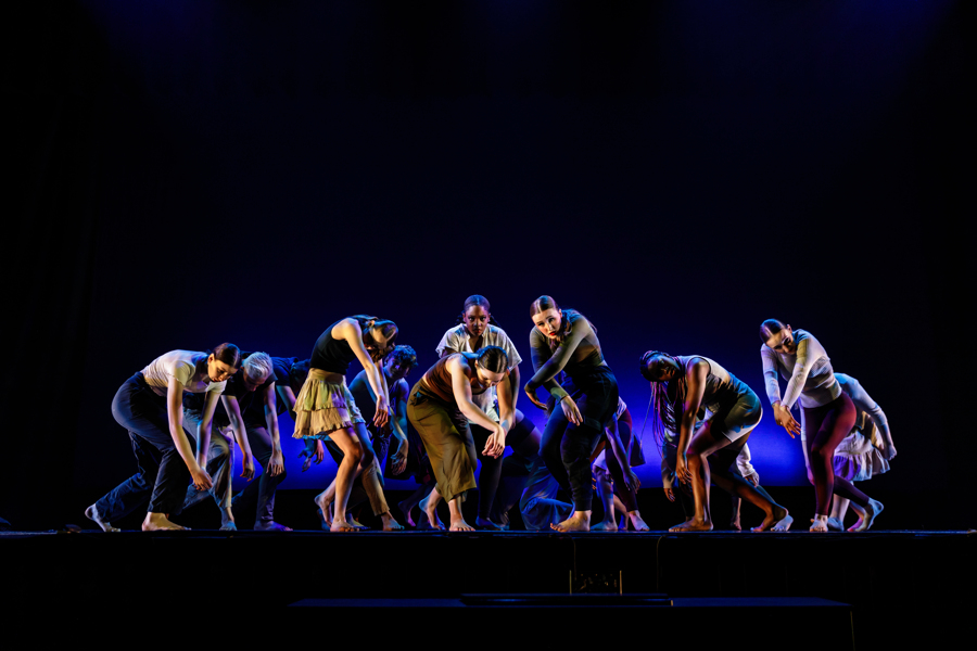 group of student dancers from Westinghouse Arts charter high school on stage under a blue light